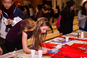 Participants writes Chinese calligraphy at the Asia Social Night.